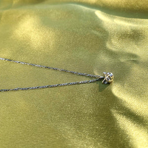 Hellhound jewelry necklace, Hellhound jewelry goth, alt jewelry, alternative jewelry, cat jewelry, cathead necklace, cat head charm necklace, charm jewelry on a green fabric background