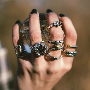 Reborn ring, skull ring, daffodil ring, hellhound jewelry ring, sterling silver ring, garnet eye skull ring, garnet ring, gemstone jewelry, gemstone, garnet skull daffodil reborn ring on hand model with other hellhound jewelry