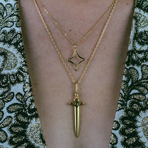 gold dagger pendant with evil eye, evil eye necklace, gold necklace, charm necklace, hellhound jewelry necklace, gold ritual dagger pendant below nebula charm necklace on model