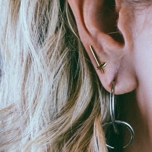 gold sword studs, gold sword earrings, gold earrings, hellhound jewelry earrings, sword earring in ear